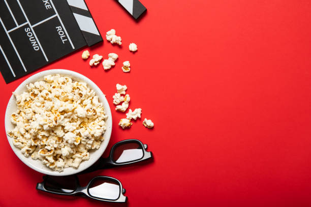 istock Plate with popcorn and movie clapper on a red background. Place for text 1226582588