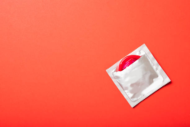 빨간색 배경에 색 콘돔. 텍스트, 맨 위 뷰에 배치합니다. 의학 및 의료 - sex object 뉴스 사진 이미지