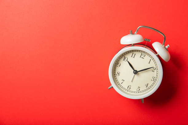 istock White alarm clock on a red background. Place for text, top view. 1226583608