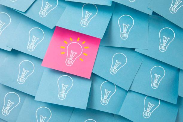 Light Bulbs Drawn on Colorful Sticky Notes Many light bulbs drawn on blue and pink adhesive notes ideas stock pictures, royalty-free photos & images
