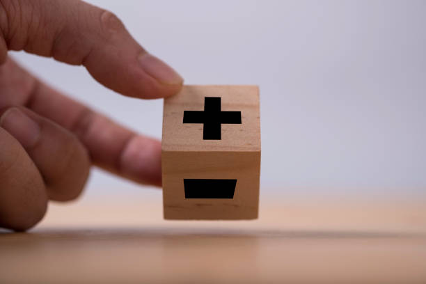 a mano volteando negro de signo más a menos que imprime la pantalla en cubo de madera. - subtraction fotografías e imágenes de stock