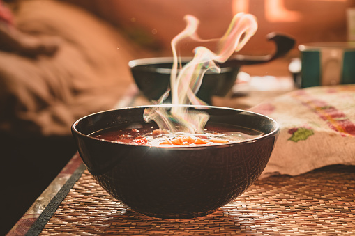 Sopa de verduras calientes en un plato hecho de materiales naturales. Almuerzo familiar tradicional en un pueblo ruso photo