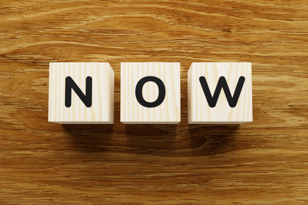 istock Now - the word on wooden blocks. 1226586940