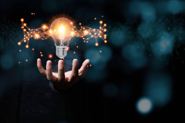 istock Hand holding light bulb glowing with orange light line and ray. Creative and new business idea concept. 1226587805