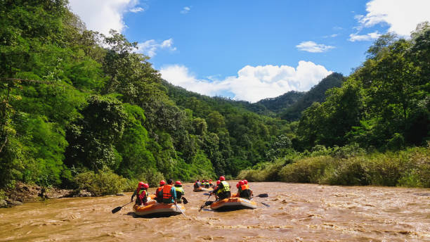 푸른 하늘과 흰색 구름 아래 화이트 워터 래프팅 모험 활동의 아름다운 풍경 사진.  이것은 태국의 장마철에서 가장 인기있는 모험 활동 중 하나입니다. - rafting thailand river inflatable raft 뉴스 사진 이미지