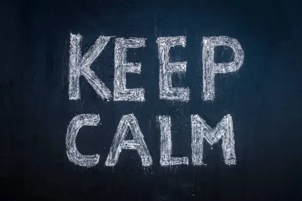 Photo of Keep calm written in chalk on a black board.