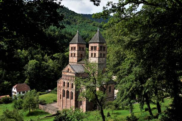 abbaye de murbach cachée derrière des arbres avec mairie de murbach - murbach photos et images de collection