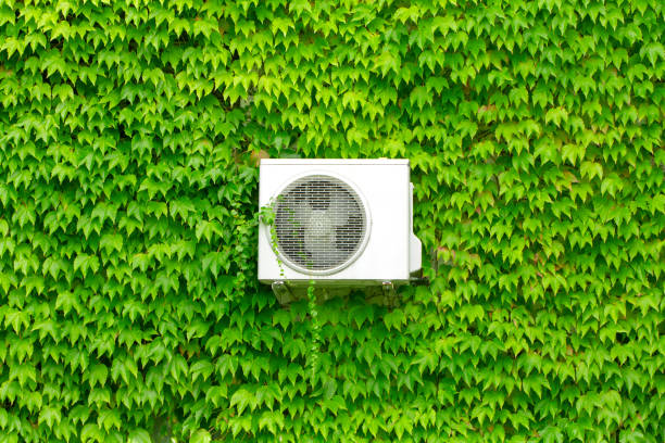 istock Air conditioning on a wall overgrown with green leaves Eco Concept 1226609652