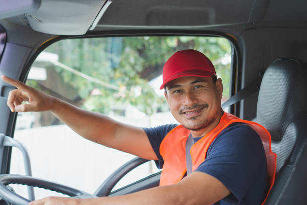 The truck driver was sitting smiling An Asian man was smiling happily at the yellow truck. He has a career as a transport driver. The transportation business never stops. It must be driven and traveled all the time. car transporter stock pictures, royalty-free photos & images