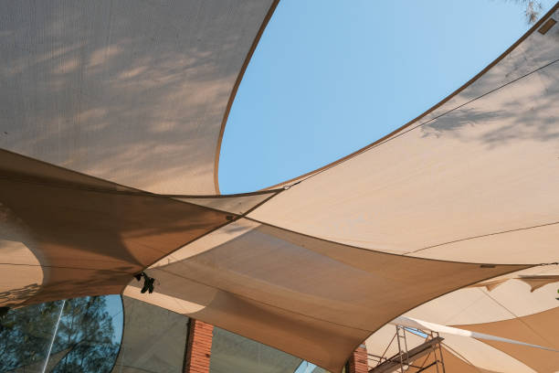 Big brown canvas umbrella with blue sky background.