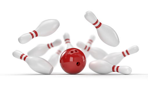 3D graphics of bowling ball and fallen skittles on the playing field (white background). shallow depth of field.