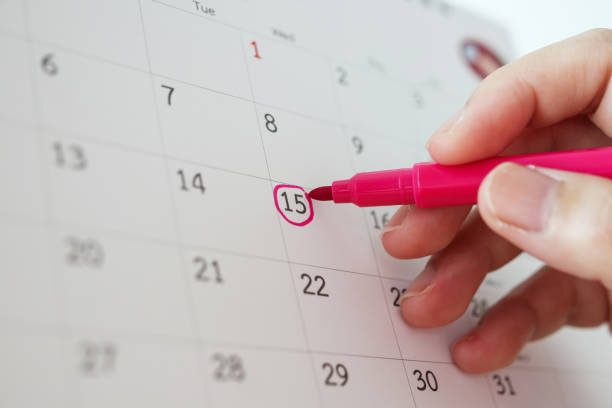 istock Hand with pen mark at 15th on calendar date 1226617986
