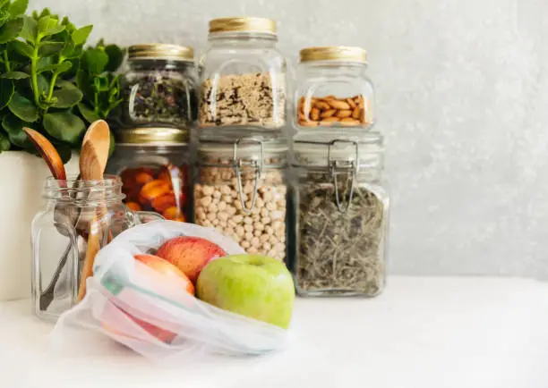Food set. Raw cereals, pasta, groats, organic legumes and useful seeds in glass jars. Vegan source of protein and energy resources. Food storage in glass jars, eco shopping, on a dark background, Zero waste storage concept, Recycling, Sustainable lifestyle concept