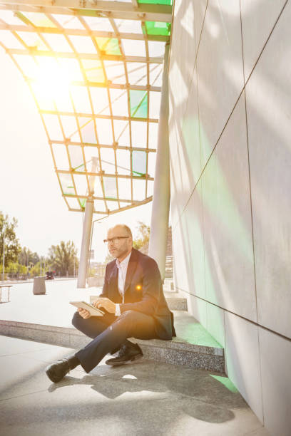 istock Portrait of businessman using digital tablet while sitting outside the office 1226619633