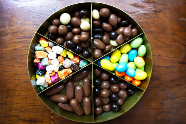 Multicolored chocolate candies on wooden table.