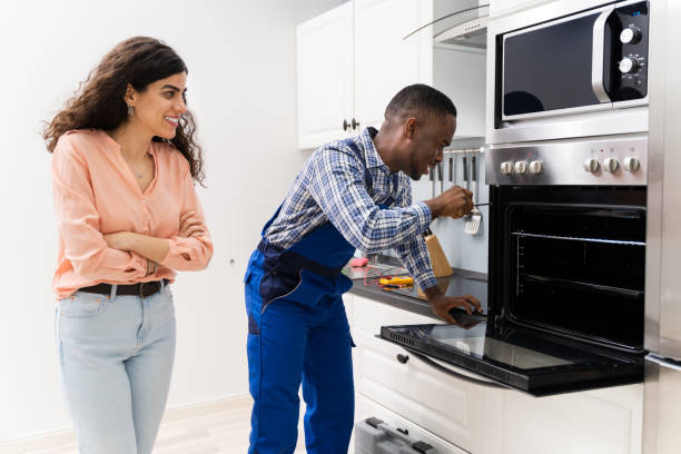 istock Woman Looking At Worker Repairing Oven 1226620451