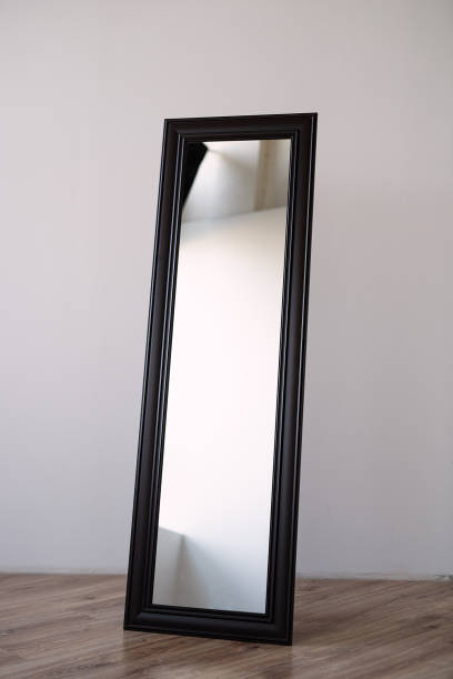 istock a rectangular mirror in a brown wooden frame stands indoors on a white background, the mirror is in an empty room 1226621965