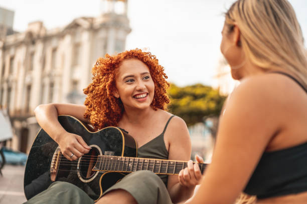 istock Young woman playing acoustic guitar 1226624587