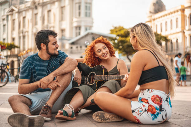 Friends singing and playing guitar outdoors