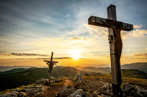 An Evocative Religious Cross on the Mountain Peak at the Sunset Time with View of the Sea