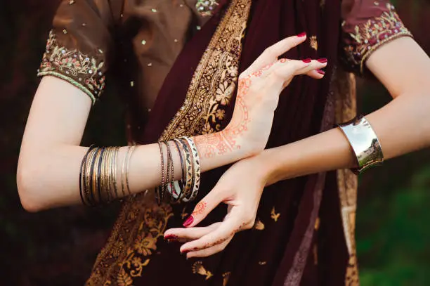 Photo of Woman Hands with black mehndi tattoo. Hands of Indian bride girl with black henna tattoos. Fashion. India