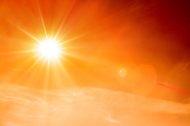 Summer background, orange sky with clouds and bright sun Orange sky with bright sun symbolizing climate change and global warming sunlight stock pictures, royalty-free photos & images