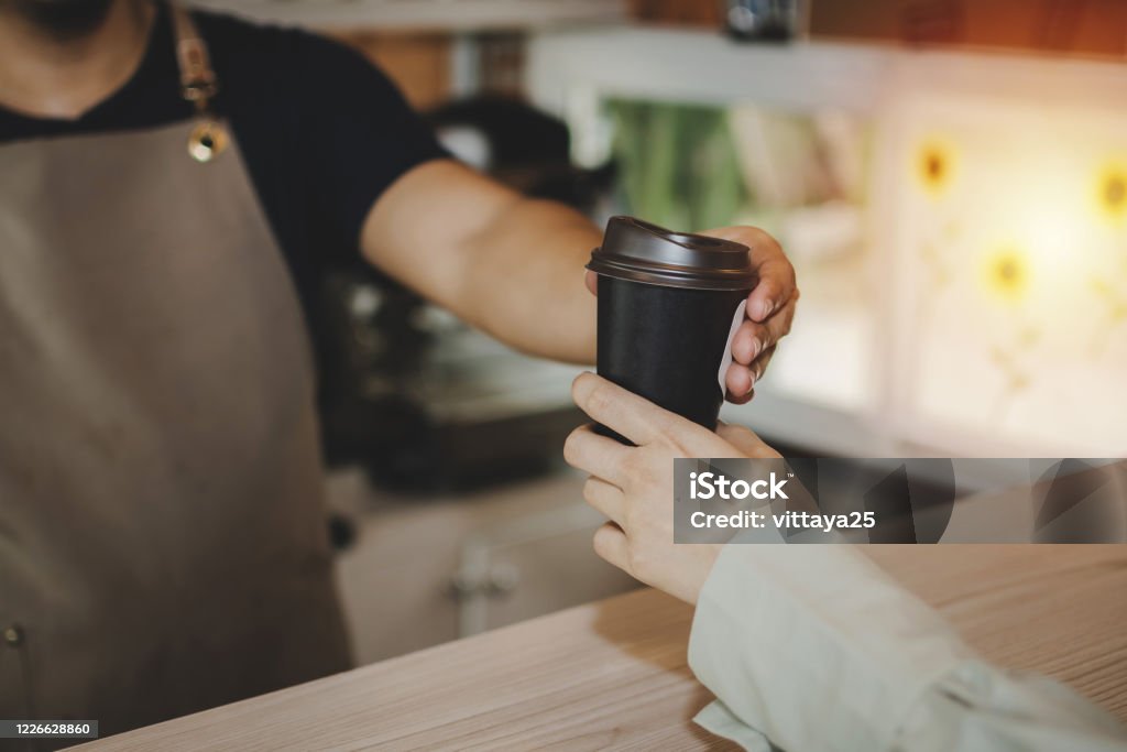 joven feliz guapo hombre barista sirviendo taza de café caliente a la mujer amable en mostrador en la cafetería moderna, restaurante cafetería, mente de servicio, pequeño negocio propietario concepto de comida y bebida - Foto de stock de Alimento libre de derechos joven feliz guapo hombre barista sirviendo taza de café caliente a la mujer amable en mostrador en la cafetería moderna, restaurante cafetería, mente de servicio, pequeño negocio propietario concepto de comida y bebida - Foto de stock de Alimento libre de derechos