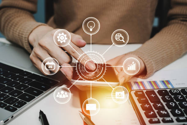 istock 5G. woman hand using digital mobile phone with virtual graphic icon, laptop computer and report on desk at home office, digital marketing, work from home, business finance, network technology concept 1226628875