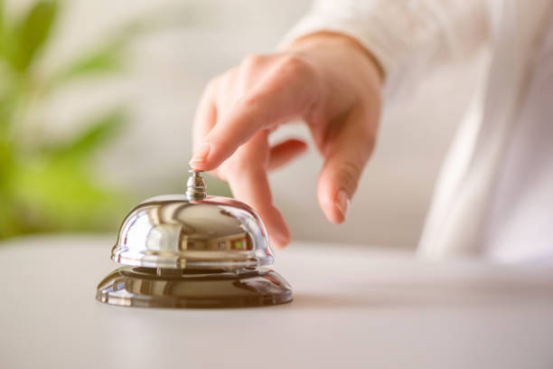 istock Hand of guest ringing in silver bell. reception desk with copy space. Hotel service. Selective focus 1226628968
