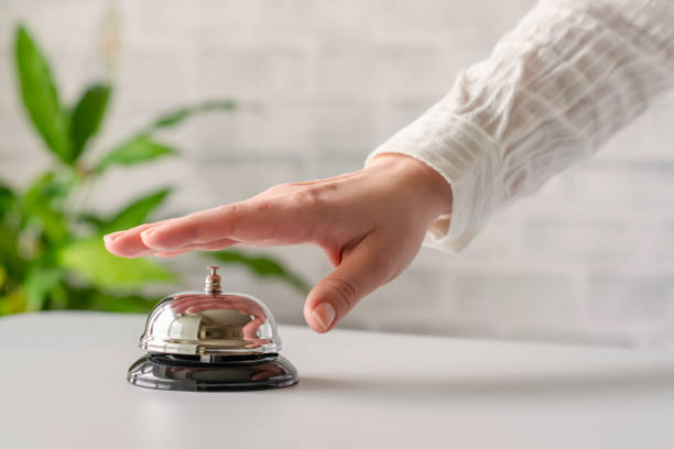istock Hand of guest ringing in silver bell. reception desk with copy space. Hotel service. Selective focus 1226629059