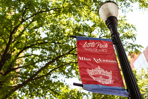 Little Rock, USA - June 4, 2019: Street sign on lamp post in summer of Miss Arkansas Pageant scholarship advertisement for beauty competition