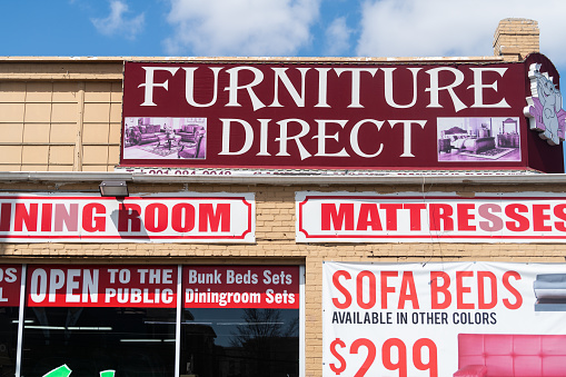 Jersey City, USA - April 6, 2018: Downtown city area in New Jersey with sign for Furniture direct warehose storeJersey City, USA - April 6, 2018: Downtown city area in New Jersey with sign for Furniture direct warehouse store