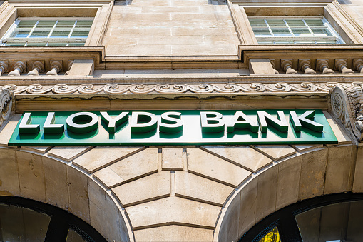 London, UK - June 22, 2018: Low angle looking up view on Lloyds Bank sign on branch office in city with historic architecture
