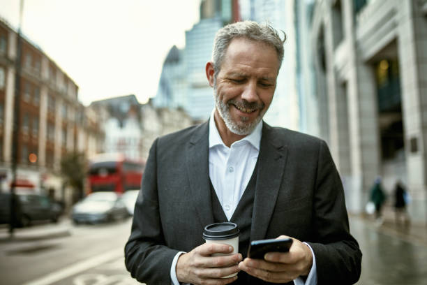 istock Smiling Businessman Checking Smart Phone on Coffee Break 1226635383