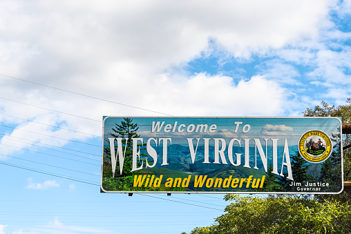 Kenova, USA - October 17, 2019: Welcome to West Virginia sign Wild and Wonderful with mountains picture and blue sky by Kentucky border