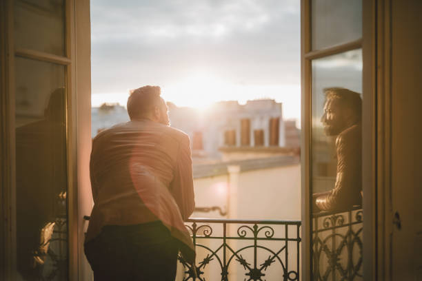 Bearded man looking out over the city at sunrise