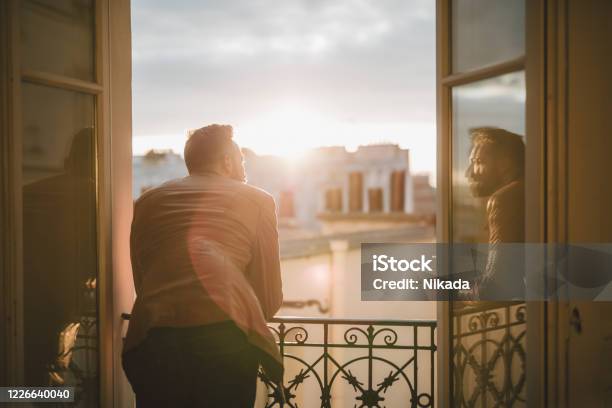 Bearded Man Looking Out Over The City At Sunrise Stock Photo - Download Image Now - Men, Looking Through Window, Window