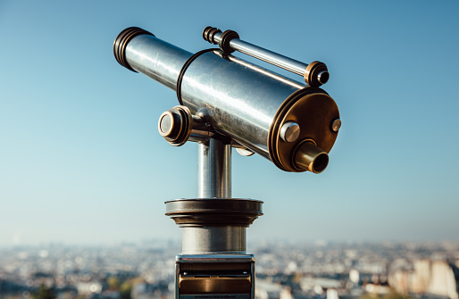 Old coin telescope looking over paris cityscape \nParis, France