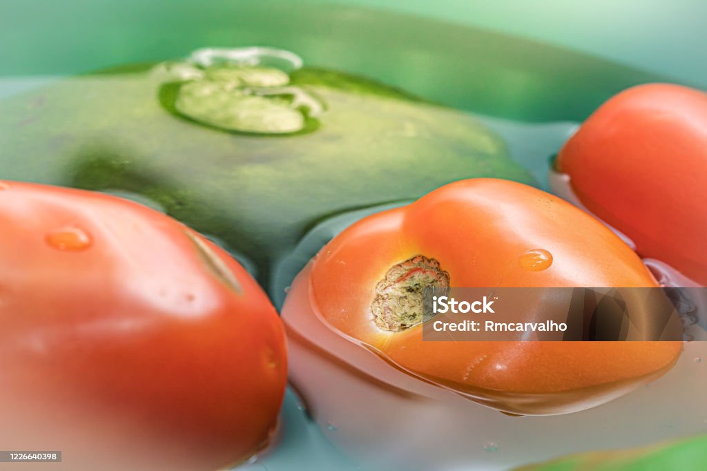 Tomato and chayote. Vegetarian food. Tomatoes and chayote being cleaned in a basin with water and sodium hypochloride. Agriculture Stock Photo