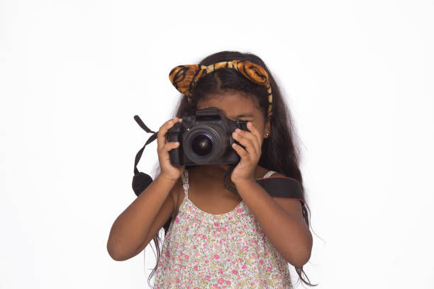 istock Beautiful girl using a digital camera isolated on white. 1226641068