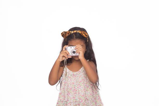 Beautiful girl using a digital camera isolated on white.