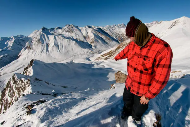 Photo of close-up of man in red jacket which indicates direction.