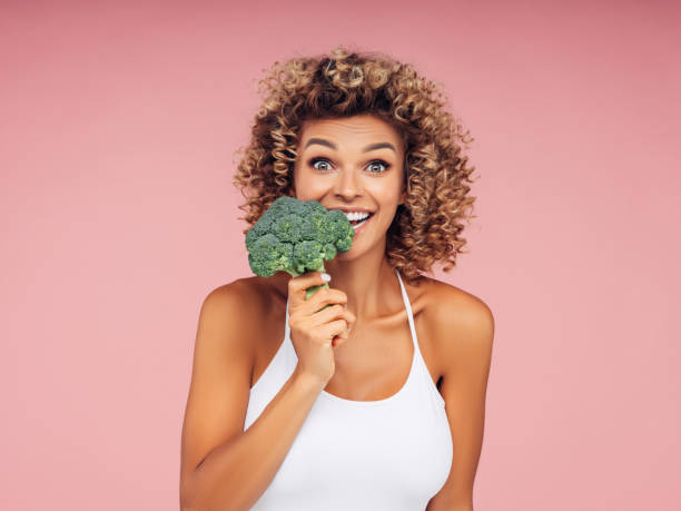 istock Beautiful girl bites fresh broccoli 1226641604