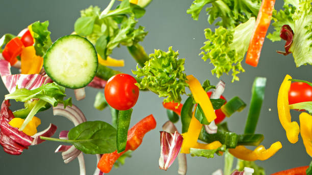 istock Flying vegetable salad isolated on green background. 1226644359