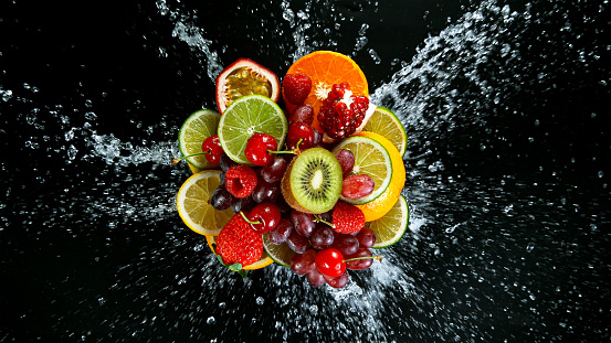 Super Slow Motion Shot of Fresh Fruits with Splashing Water Isolated on Black Background.
