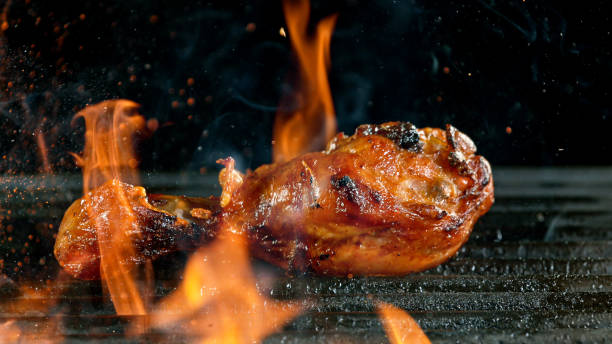 istock Tasty chicken legs on cast iron grate with fire flames. 1226644612