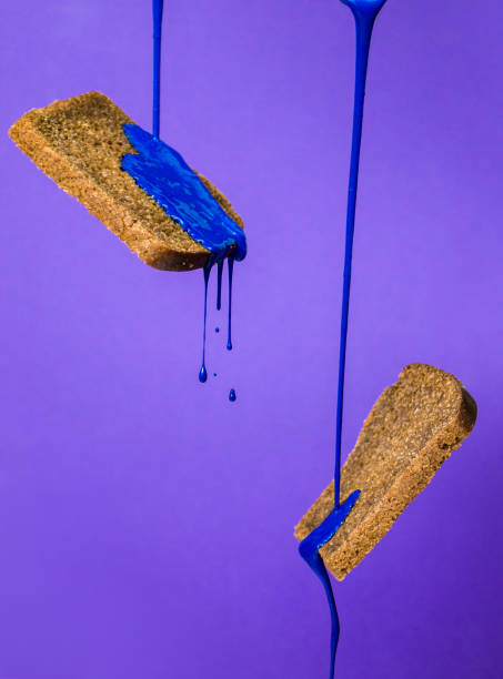 istock Concept idea : blue liquid paint flows down on slices of dark bread on violet background 1226650766