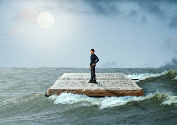 man sailing on the holy bible, in rough seas, seeking salvation by faith in jesus christ, son of god. - bible holding reading book imagens e fotografias de stock