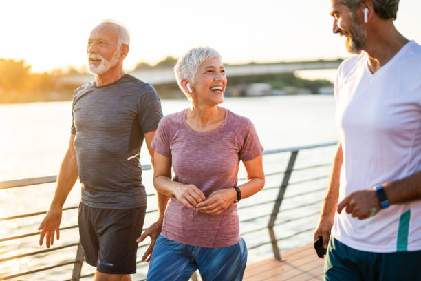 istock Smiling senior athletes jogging by the river. 1226652101