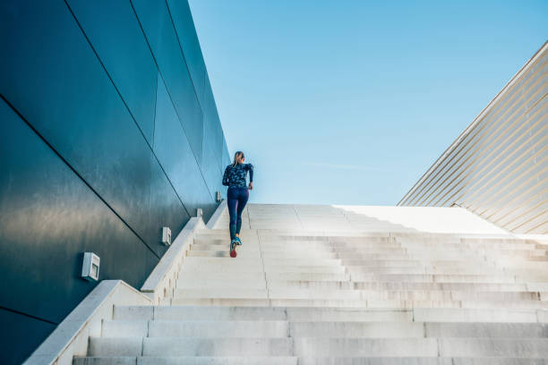 femme courant sur l’escalier de ville. - jumping women running vitality photos et images de collection